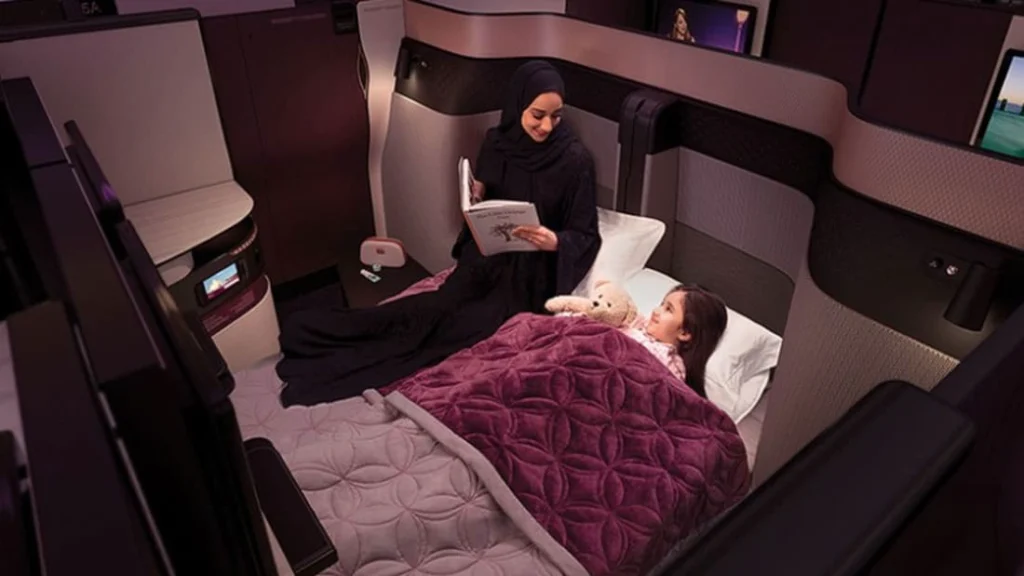 مقعد مريح في درجة رجال الأعمال أو الدرجة الاقتصادية بطائرة تابعة للخطوط القطرية، يُظهر التصميم الأنيق ومساحة الأرجل الواسعة ضمن تجربة سفر راقية